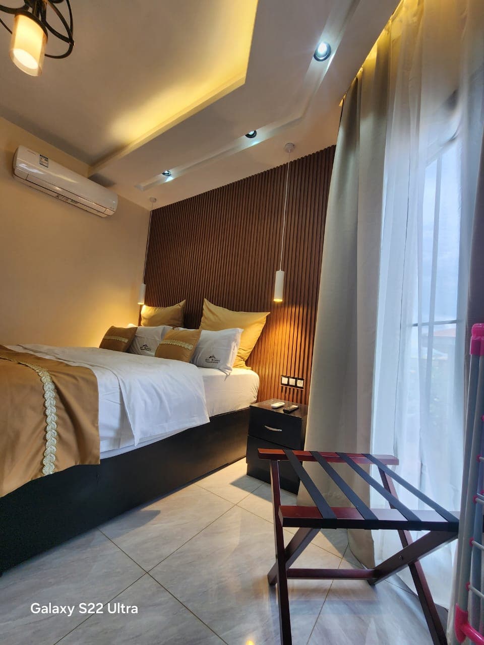 Chambre avec tête de lit en bois et suspensions